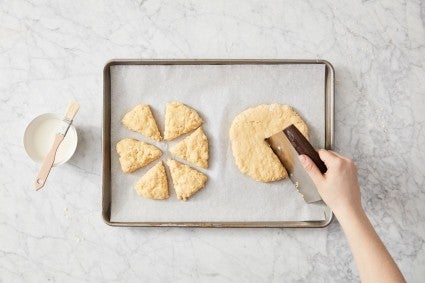 Scones being cut on a baking sheet for freezing